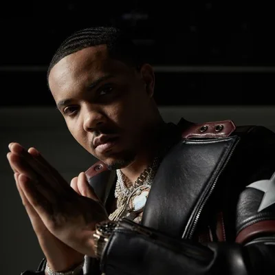 Portrait sombre de G Herbo, mains jointes, chaînes en or