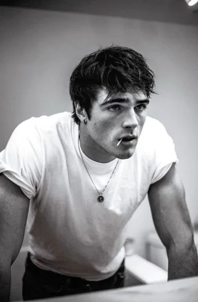 Jacob Elordi en noir et blanc, t-shirt blanc et cigarette, penché en avant