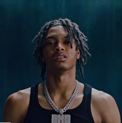 Nemzzz en débardeur noir et chaîne DND, ambiance bleutée de clip
