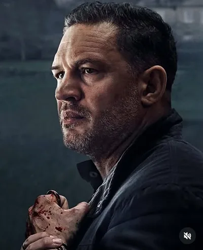 Portrait cinématographique sombre de Tom Hardy, la main tachée de rouge